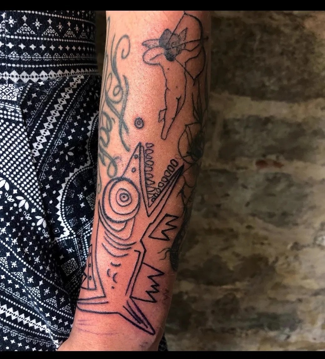 A Sesow fish tattooed on a collector's forearm